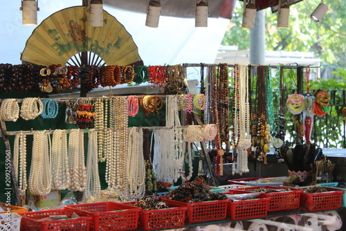 Market stall showcasing collection of handmade beaded necklaces and jewelry goods.