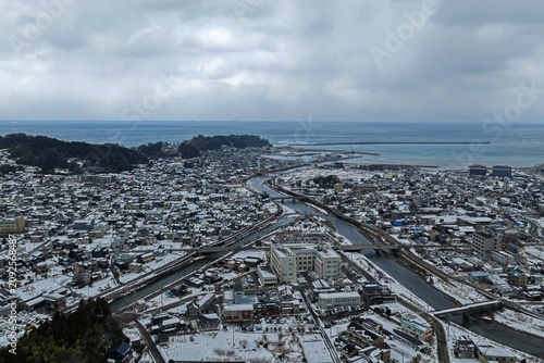 Bild auf Leinwand Aerial drone photo of snow-covered Wajima city and river flowing to the sea, Ish