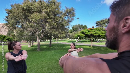 A coach leads an outdoor training session with two women