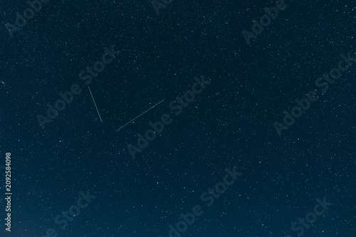 Fotografía A stunning wide shot of a deep midnight blue sky scattered with countless bright white sparkling stars during a clear night in outer space