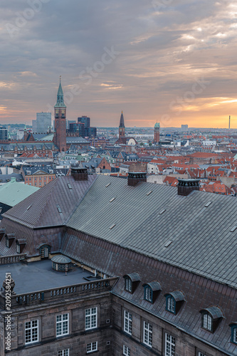 Copenhagen Denmark - August 12 2025. A rooftop viewpoint looks out across the old town of Copenhagen beneath a clear blue summer sky in a warm afternoon glow.