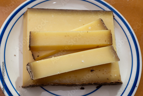 Comte hard french cheese from France's Jura Mountains made from unpasteurized cow's milk with traditional methods in cooperative dairies with nutty flavor, creamy texture, aged in natural caves