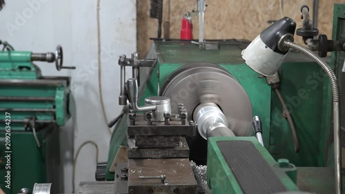 A lathe is installed in the production workshop. An electric lathe removes a layer from a metal workpiece, shaping it into a finished product. Production of metal products.
