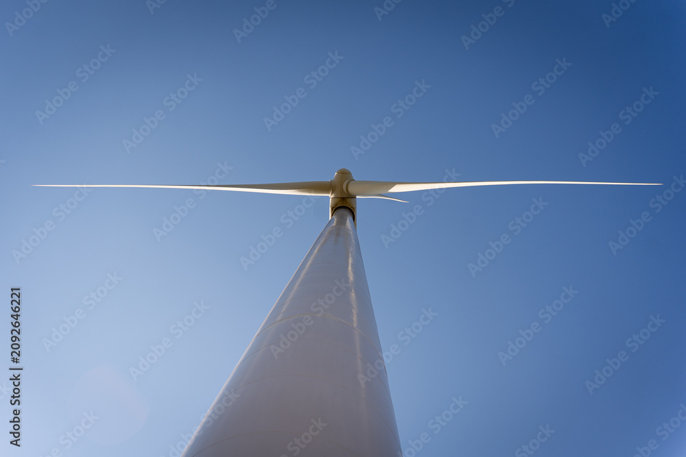 Fototapeta premium close up of one wind turbine in a windfarm seen from below, power plant for renewable electric energy source
