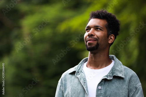 Peace and harmony. Happy man relaxing in park, space for text