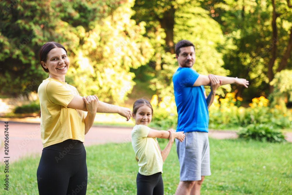 Obraz premium Happy family doing morning exercises in park, selective focus