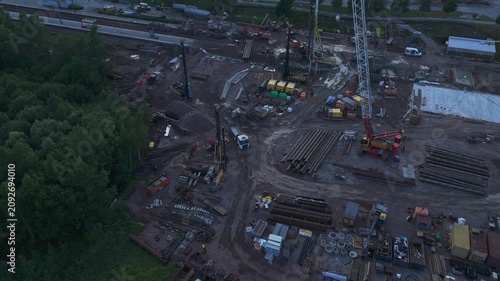 High altitude drone shot of construction cranes and excavators building modern residential district with expanding infrastructure