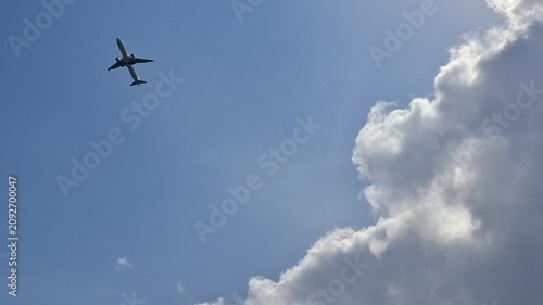 Airplane flying in a blue sky with clouds. travel, flight, aviation, outdoors, transport.