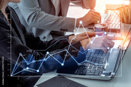 Foto Business professionals collaborate on financial data analysis using laptops in an office setting