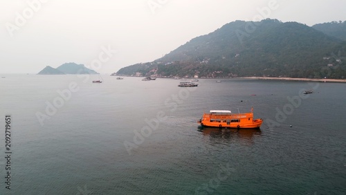 Foto Orange longtail boat anchored near the island coast at Koh Tao