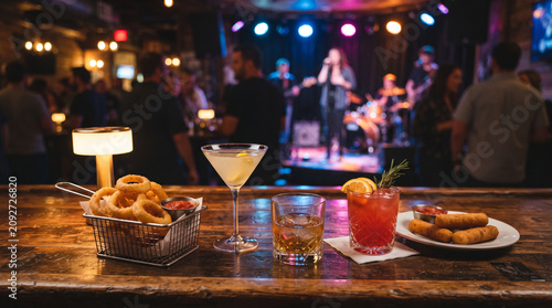 Assorted cocktails and appetizers on a rustic bar counter in a live music nightclub