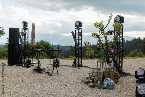 Outdoor concert stage setup with lighting equipment and sound system in the mountains.