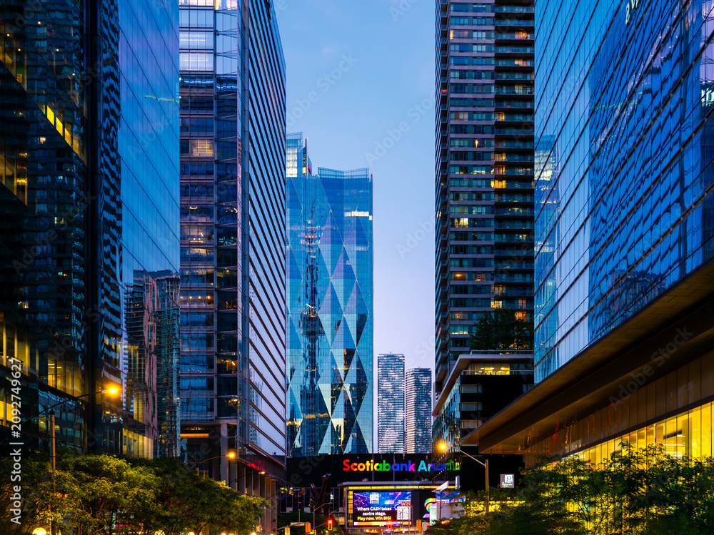 Obraz premium Toronto, ON, Canada - Jun 27, 2025: Twilight view of Scotiabank Arena and skyscrapers around it located in downtown Toronto, ON