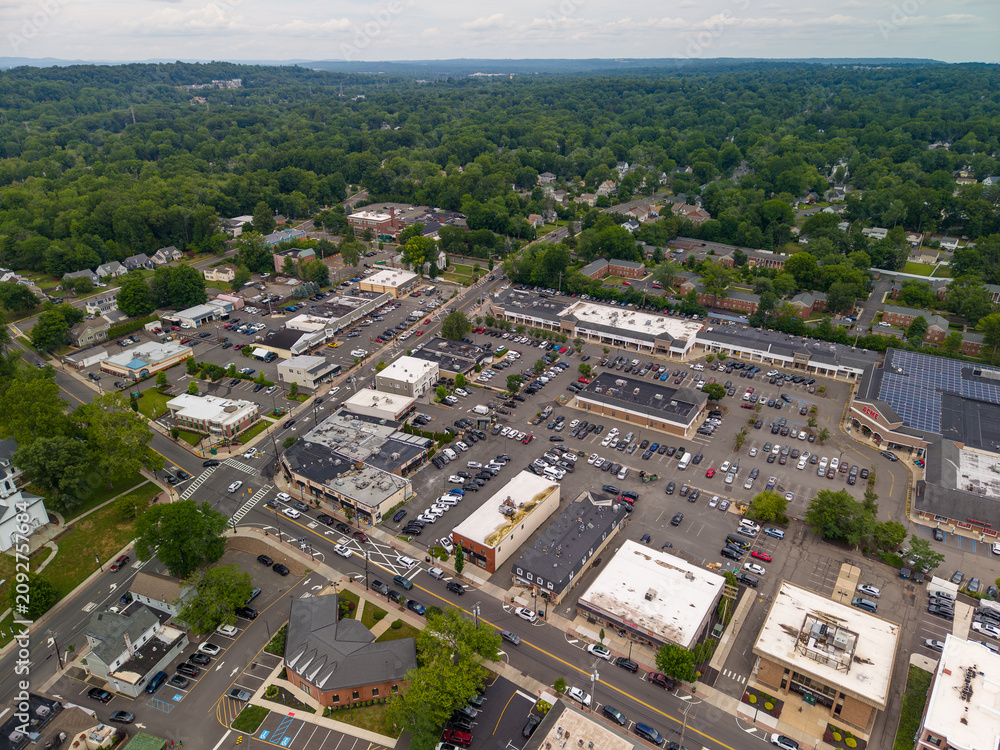 Fototapeta premium Aerial view of suburban town center with parking lots and shops