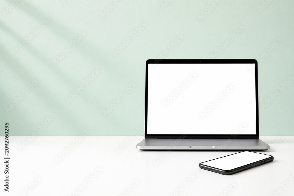 Fototapeta premium Laptop and Smartphone Blank Screen Mockup in Bright Home Office