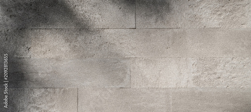 Foto A textured background featuring grey stone tiles arranged in a seamless pattern, showcasing a blend of light and shadow for an industrial feel