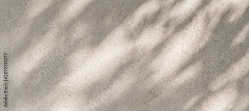 A close-up view of a textured surface showing soft, abstract shadows cast by light. The tones are neutral and create a calming, minimalistic aesthetic.