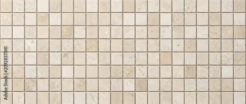 Beige limestone mosaic tile texture with natural stone squares creating a seamless surface for timeless interior wall designs