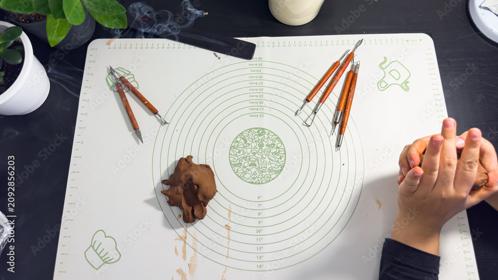 Obraz premium Hands sculpting with brown self-hardening clay close up