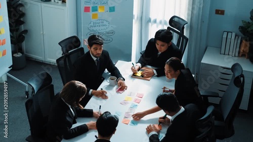 Top view of smart business team brainstorm idea by writing in sticky notes at meeting. Group of professional analysts planning marketing strategy and brainstorming in conference. Teamwork. Directorate