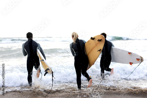 Surfers entering ocean waves photo