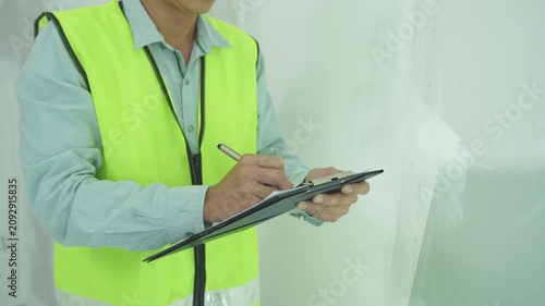 inspector or engineer is inspecting construction and quality assurance new house using a checklist. Engineers or architects or contactor work to build the house before handing it over to the homeowner