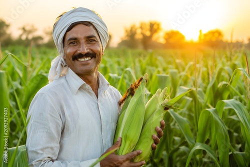 Smiling Indian Farmer Holding Fresh Corn Harvest