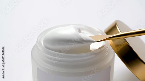 Macro Close-Up of Luxurious Moisturizer Cream Being Scooped with Gold Spatula on Clean White Background