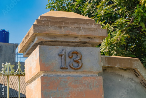 Schilderij op canvas House number 13 on a concrete pillar with a superstitious and mythical concept