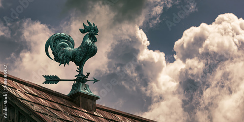 Rooster Weather Vane on a Wooden Roof with Dramatic Clouds