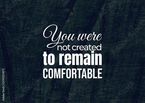 Foto Inspirational typography featuring “You were created to remain comfortable,” presented in elegant white lettering over a deep blue textured background