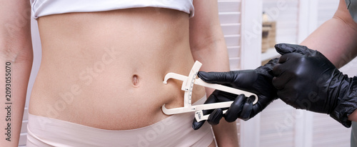 Body Fat Measurement with a Caliper on a Womans Belly