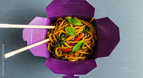 Overhead View of Stir-Fry Noodles with Vegetables in a Purple Takeout Box