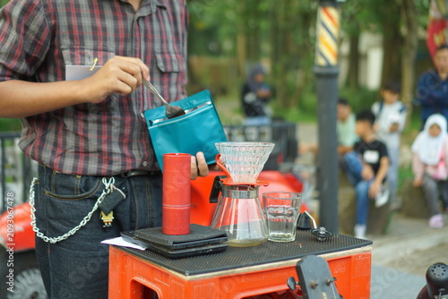 Φωτογραφία Barista preparing specialty coffee at outdoor market stall.