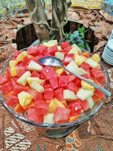 Colorful tropical fruit salad with watermelon pineapple and melon in glass bowl, fresh healthy food concept with vibrant natural colors.