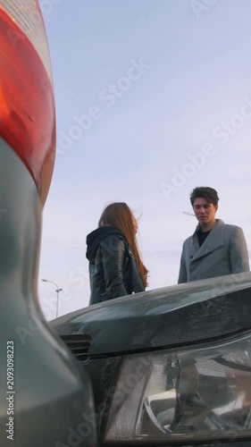 Young man and woman argue because of the car accident