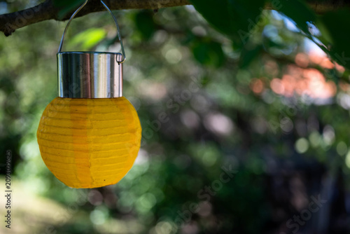 Hanging led yellow fabric lantern , shallow depth of field, space for text.