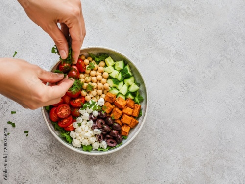 Preparación de una ensalada saludable con varios ingredientes frescos en un tazón grande