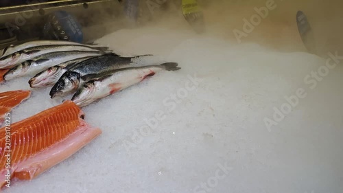 Fresh raw fish on ice with cold steam mist at seafood counter