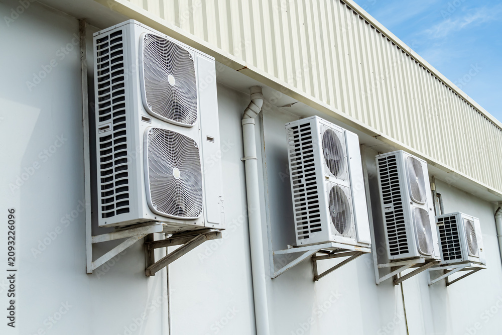 Fototapeta premium Air conditioner air compressor cold electric fan cooling temperature external on wall cement building outdoor construction, electric fan power supply technology