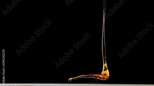 highspeed. A droplet of golden liquid falling in slow motion against a dark background. bar promotions, beverage menus, designed for food & beverage menus and cafe branding.