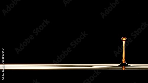 highspeed. A droplet of golden liquid falling in slow motion against a dark background. bar promotions, beverage menus, designed for food & beverage menus and cafe branding.