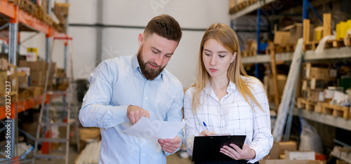 Foto Logistics Managers Reviewing Shipping Manifest and Documents in Warehouse