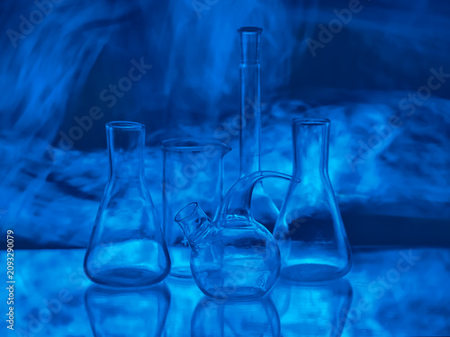 Canvastavla Empty glass laboratory flasks and retorts in dark blue neon light with mysteriou