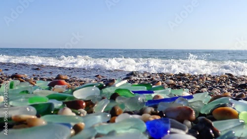 Sea glass, Green pieces of glass polished by the sea closeup background. A pile of natural beach glass, Multi colored pieces of polished glass. Color. Beach pebbles and shells in the Mediterranean sea