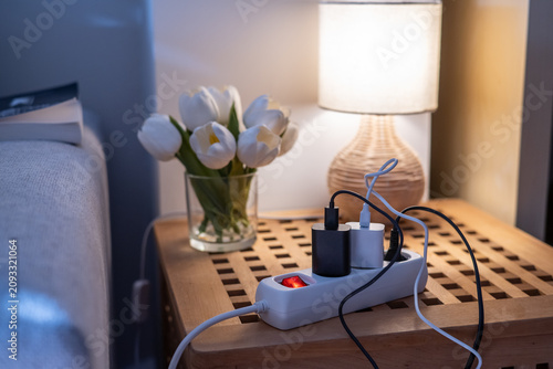 Bild auf Leinwand Power strip with multiple chargers plugged in, illuminating with a red switch, p