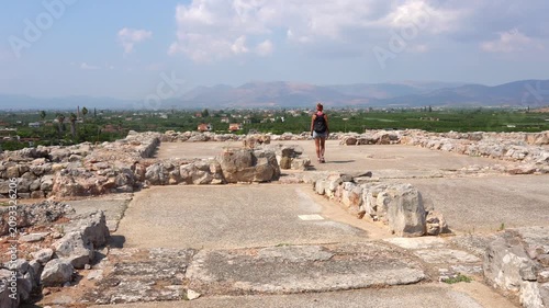 Woman walking through the Tiryns archaeological ruins in Greece