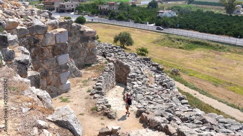 Female traveler exploring ancient Tiryns acropolis ruins in Greece