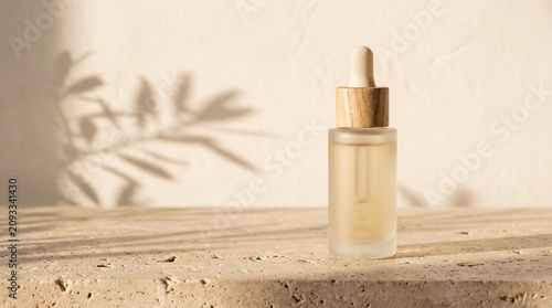 Dropper bottle of oil on neutral stone background with shadows  