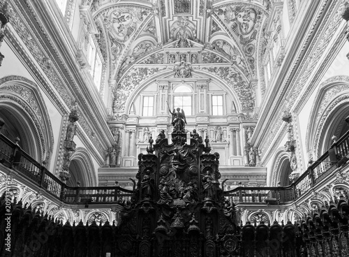 Ornate interior of the Mezquita-Cathedral in Córdoba, Spain, showcasing intricate architectural details in a black and white photo.